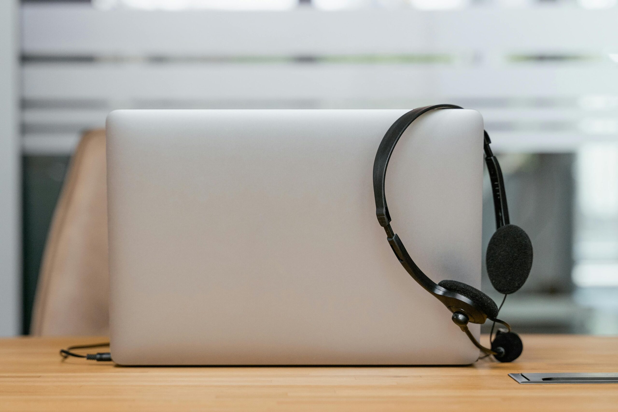 Ein Headset hängt an einem Laptop.